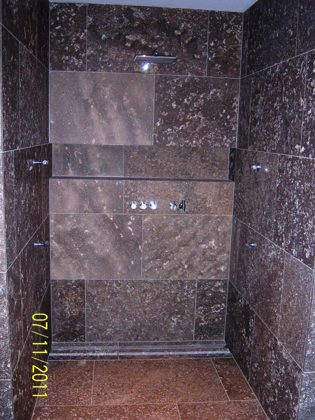 Duschbereiche Ebenerdiger Duschbereich mit Wandund Bodenbelägen aus Muschelkalk Speziell angefertigte