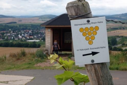 Auf der rechten Seite steht eine neu errichtete Schutzhütte, hingegen auf der linken Seite sich noch der alte Rastplatz in Form einer Steinbank unter einem großen Walnussbaum befindet.