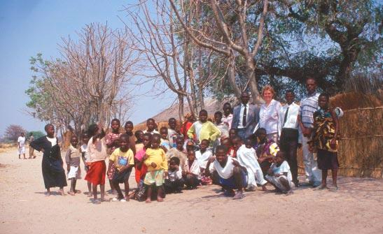 Louise Warburton mit Schülern und Lehrern der Mulanga Grundschule. Wasser und Nährstoffe entziehen würden.