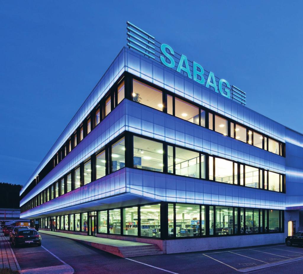 Der Hauptsitz der SABAG Gruppe in Biel, leuchtendes Symbol für ein Unternehmen, das seit 1913 für konstruktive Innovation in den Bereichen Küchen, Bäder, Platten und Baumaterial steht.