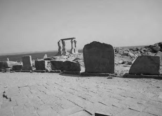 Einige der mysteriösen Steinplatten, die hinter dem Mandulis-Tempel an einem Weg aufgestellt sind. Im Hintergrund das Hathor-Tempelchen.