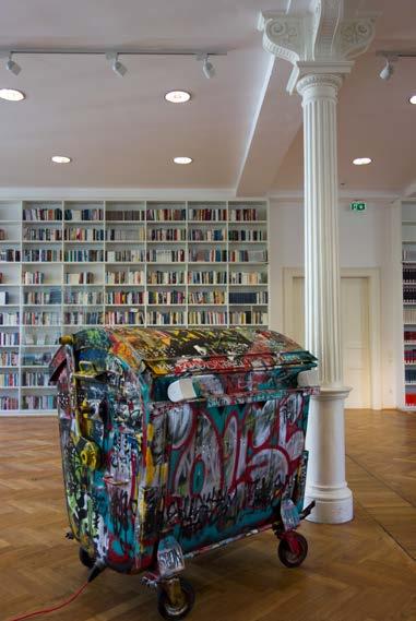 Die Mülltonne, hier aus gestellt im Literaturhaus München, 2015, ist über und über besprüht.