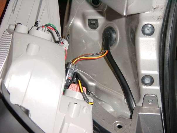 Linke Seite Den fahrzeugseitigen Heckleuchtenstecker mit der Tülle ins Fahrzeuginnere führen. Durch die Öffnung den linken Leitungsstrang mit 24- pol., 3- pol., 6- pol.