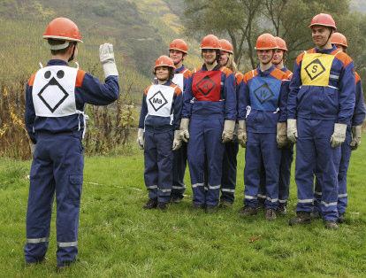 Schutzhelm nach DJF-Bekleidungsrichtlinie in festem Schuhwerk mit Schutzhandschuhen nach DJF-Bekleidungsrichtlinie mit Brusttüchern Taktische