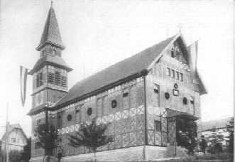 1904 wird auf diesem Grundstück mit der Erstellung einer eigenen Kirche begonnen. Es erstand in diesem Jahr ein Kirchlein in Fachwerk mit etwa 150 Sitzplätzen.