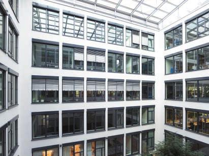 Dem Bürogebäude ist eine Natursteinfassade vorgehängt und ein Innenhof unterstützt das transparente Konzept des