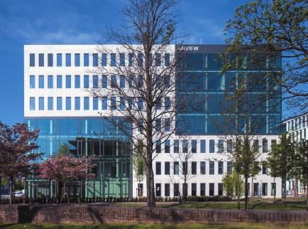 000 qm großer Bürotrakt, der mit seiner strukturierten Stahl-Glas-Architektur und den großen, blau leuchtenden Lichtkuben