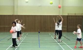 Während der Ball in der Luft ist, drehen sie sich um und fangen den entgegenkommenden Ball mit beiden Händen sicher auf.