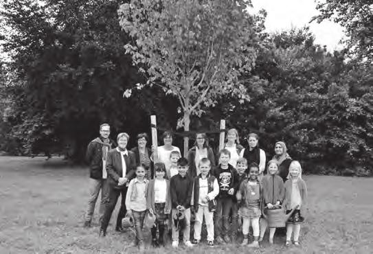 Die Schulleitung, die Kinder und der Fachbereich Grünfl ächen freuen sich über den neuen Baum, der nun ordentlich gewässert werden muss, damit er gut anwächst.