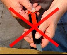 Zeigefinger unterhalb der schwarzen Klingenklappe halten, damit Klinge nicht hinunterfällt. Klinge wenden oder wechseln.