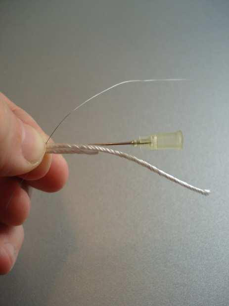 4. Das Wickeln Das Glasfaserpaket zwischen Daumen und Zeigefinger nehmen. Die Wickelhilfe hinter die Glasfaser platzieren.