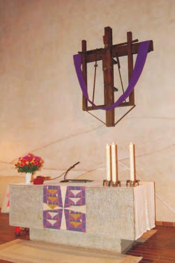 Der Altarraum ist 2 Stufen erhöht und wird in der Mitte durch den Altartisch aus einem grauen Kalksteinblock bestimmt.