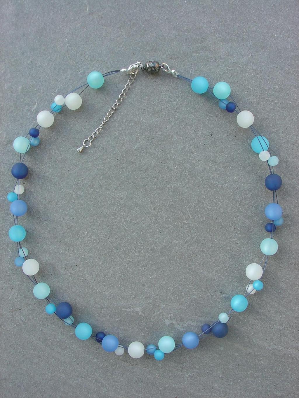 Blauregen Edle Polarisperlen in den Himmelsfarben auf blauem Dreifachfaden. Unterschiedlich große Perlen präsentieren sich sportlich leicht.