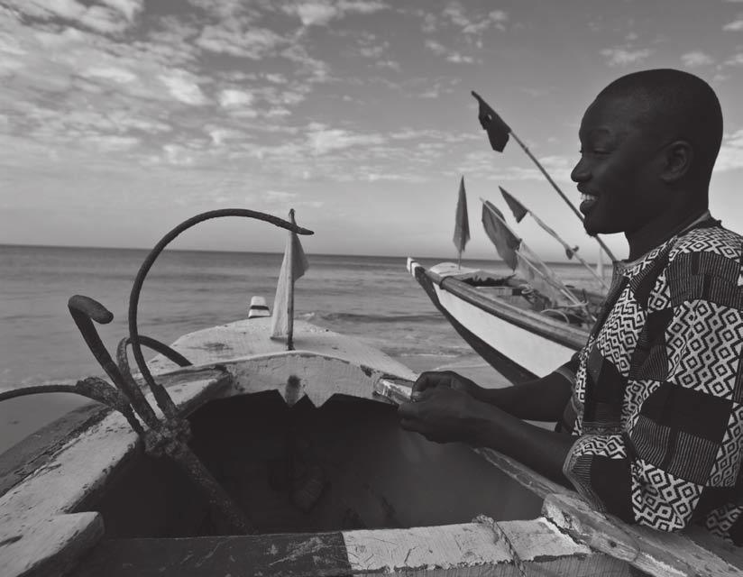 Arbeitsblatt: Leere Netze 4 Schlafende Netze Badara Diop, ein Fischer nahe der Hauptstadt Dakar, macht am Strand seine Piroge zum Auslaufen klar.