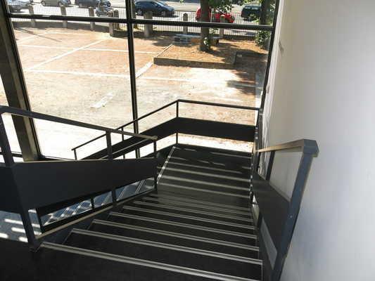 Es sind keine kontrastreichen Stufenflächen vorhanden. Es besteht ein visueller Kontrast zwischen dem Fußbodenbelag und Treppenauf- oder abgängen.