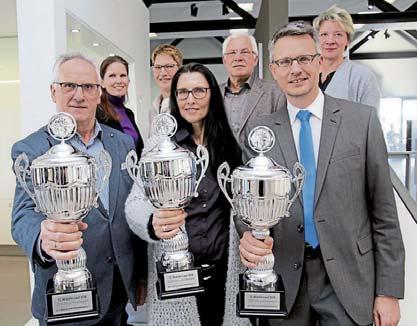 Der Vereinsvorsitzende des TuS, Horst Brinkmann, nimmt einen Pokal für die meisten Teilnehmer eines Vereins am letztjährigen Widufix-Lauf entgegen.