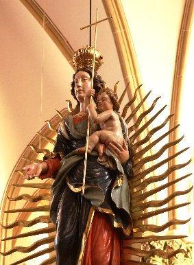 Nun fällt beim Gang zum Altar der Blick auf die apokalyptische Strahlenmadonna, eine Figur,die uns Maria mit dem Jesuskind auf dem Arm stehend auf der Sichel des Mondes zeigt, die zertretene