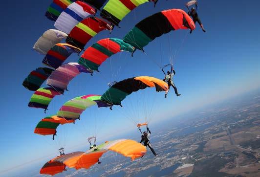 Diese Fallschirmspringer wissen, wie man Fallschirme zueinander fliegen und sicher mit ihren Füßen in den Fangleinen anderer Schirme verbinden kann.