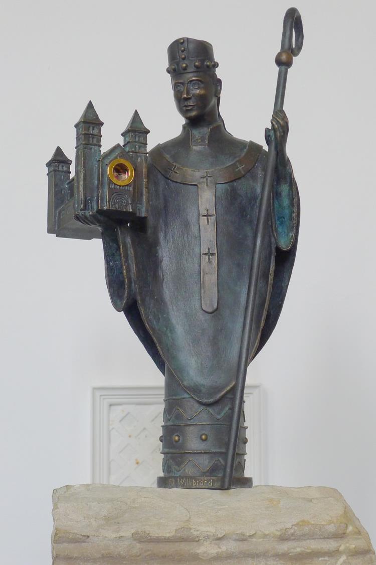 Hl. Willibrord mit einem Modell der Echternacher Abtei-Kirche als Träger einer Reliquie des Heiligen auf einem Stein der von Willibrord gegründeten Abteikriche, gestiftet vom Willibrordus-Bauverein,