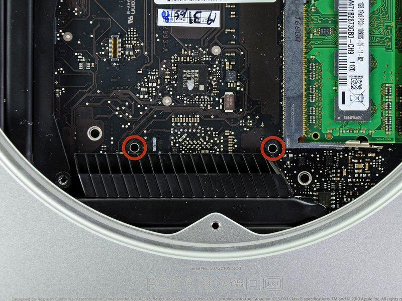 Schritt 15 Um die Hauptplatine zu entfernen müssen die beiden zylindrischen Stäbe des Mac Mini Logic Board Removal Tools in die beiden rot markierten Öffnungen eingeführt werden.