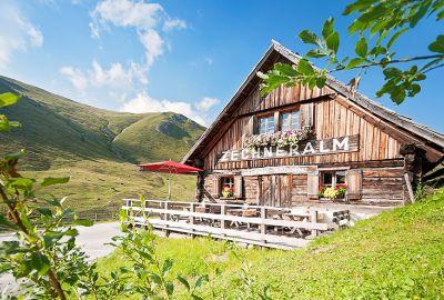 Die Berge tragen leuchtende Frühjahrs-Farben und spiegeln sich in smaragdgrünen und tiefblauen Seen