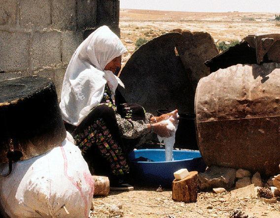 Shabtai Gold / IRIN In Samua im Süden der besetzten Westbank wäscht eine Palästinenserin draußen im Freien Kleidungsstücke.