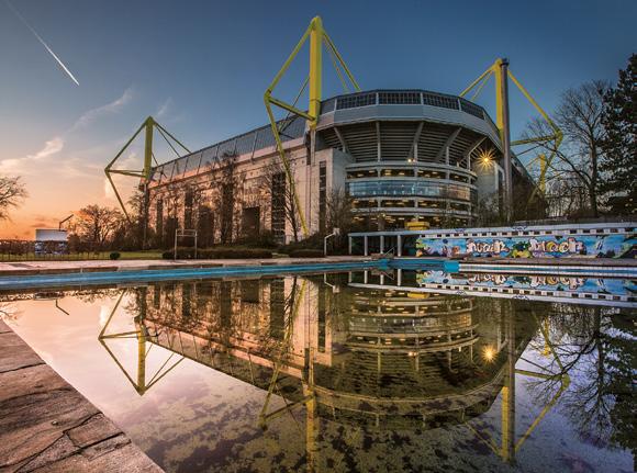 Farbenfrohe Aufnahme der BVB-Arena, die sich im Wasser des