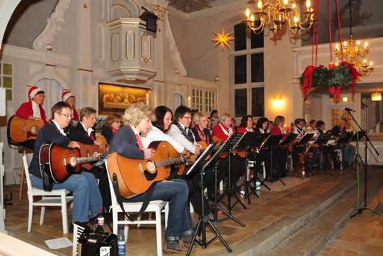 35 Gitarristinnen aus den drei Asendorfer Gitarrengruppen (rot/weiß/blau) im Altarraum der Kirche einfinden, um ihre Lieder vorzustellen und gemeinsam mit den Gästen zu singen.