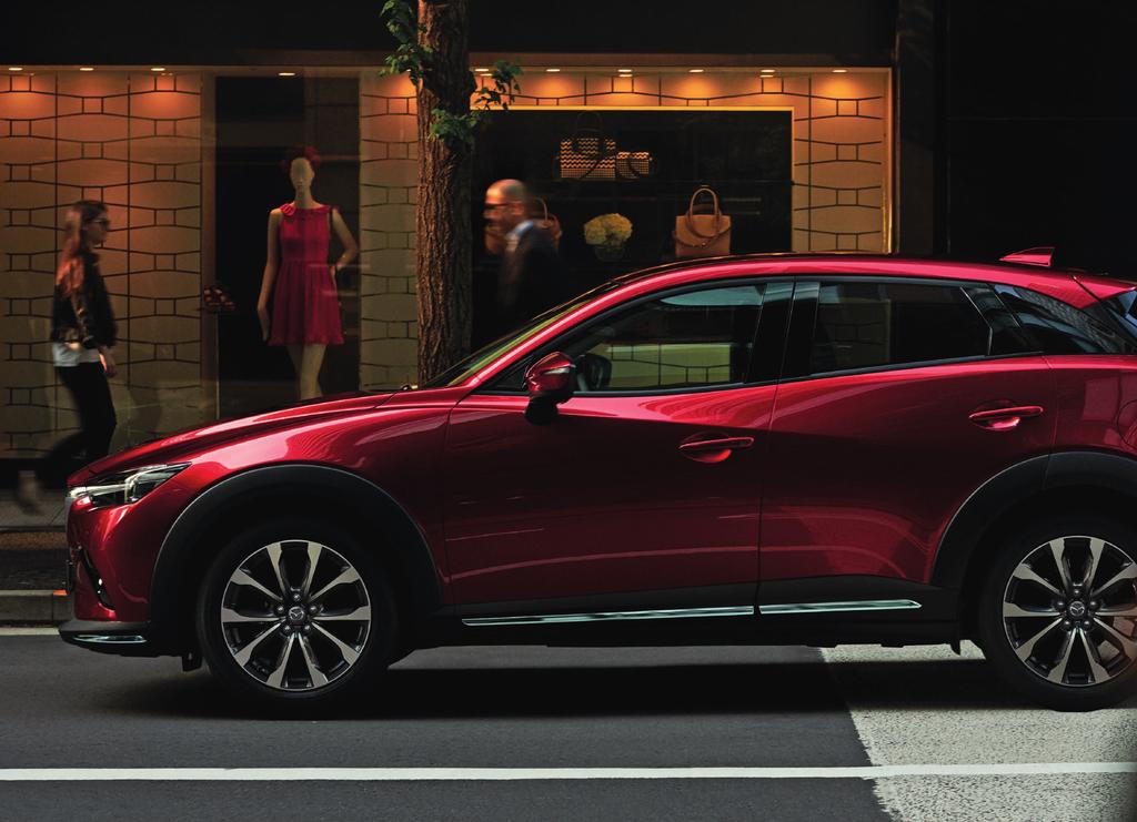 Die Abbildung zeigt einen Mazda CX-3 mit werkseitig optionaler Sonderfarbe Magmarot Metallic.