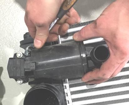 Uninstall the lower cross member and remove all charge air hoses from the stock intercooler.