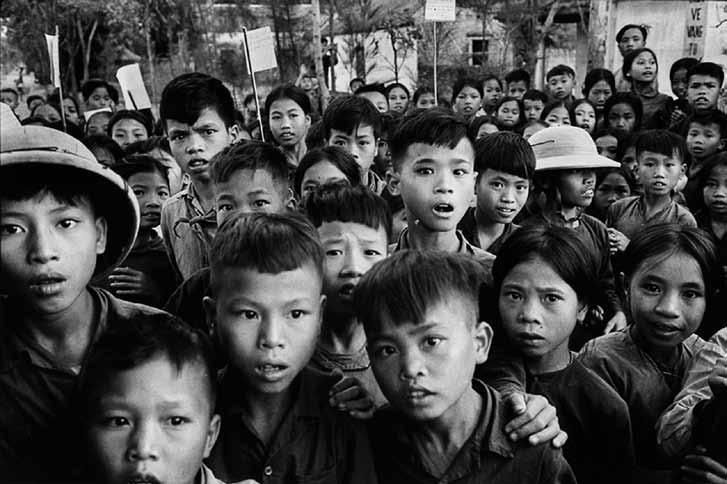 Ein aufregender Moment! Suche dieses Foto und schaue Dir die Gesichter der Kinder genau an! Dieses Foto hat Marc Riboud vor ungefähr 50 Jahren in einem kleinen Dorf in Vietnam gemacht.