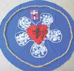 Darum ist es gut, dass das Herz für die Liebe und das Kreuz für den Glauben und die Rose für die Freude auf einem blauen Tuch liegen.