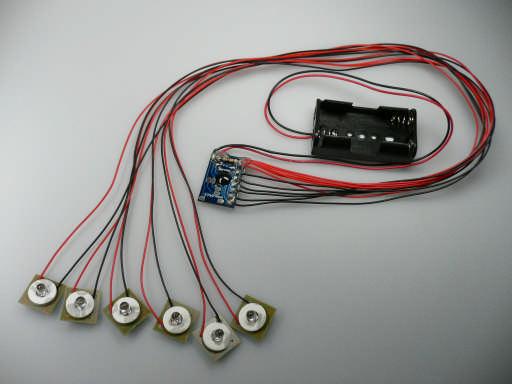 Multi-LED-Blinker Abb.: 6-fach LED-Blinker, weiß mit serieller Blinkfolge und Batteriehalter LEDs sind auf kleinen, mit Kabeln verbundenen Einzelplatinen montiert.