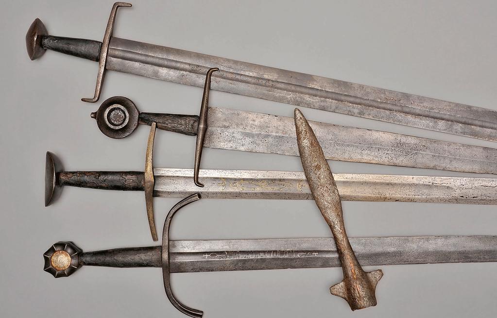 Ritterliches Schwert, dt. um 1200. Hiebklinge mit flacher Hohlkehle, beidseitig mit ornamentalen Messingeinlagen, abgewinkelte Parierstange, Paranussknauf.
