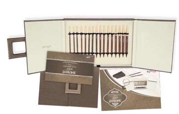 Ein Set von 8 austauschbaren Nadelnspitzen aus laminiertem Symfonie Rose Wood Holz, verpackt in einer Kunstlederbox» Dem Set liegt eine elegante Symfony Wood Tuchbrosche bei» Die Metallteile sind mit