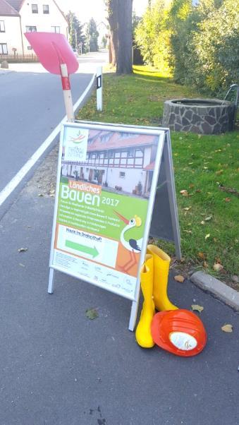 Eröffnung und Begrüßung Der Aufsteller mit Plakat, Bauhelm,