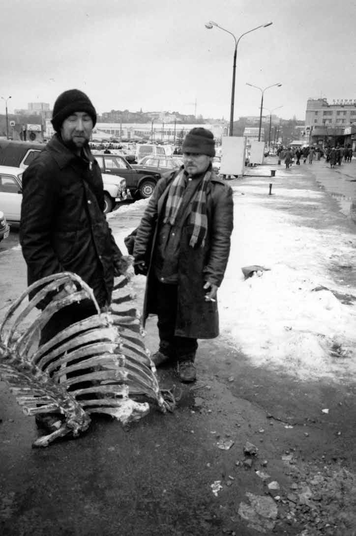 C/O Berlin Boris Mikhailov Before Sleep / After Drinking Es ist Winter. Zwei Männer stehen am Straßenrand, der Schnee auf dem Asphalt um sie herum ist zertreten.