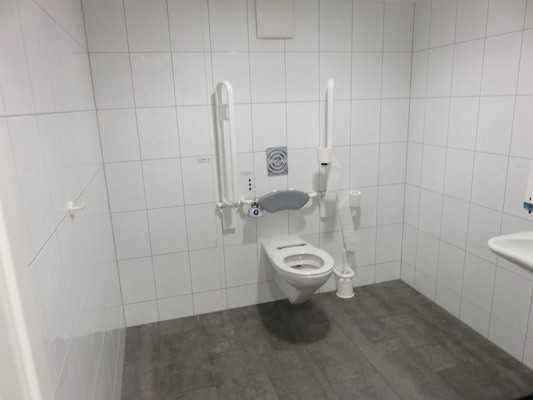 Es ist ein Damen WC. Es ist ein WC für Menschen mit Behinderung vorhanden. Tiefe der WC-Schüssel: 70 cm. Die Bewegungsfläche links vom WC ist 96 cm breit.