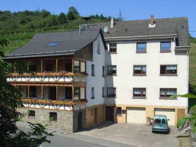 Unser Ferienhaus ist in einem kleinen Ort in der Eifel. Am Haus gibt es eine Terrasse, auf der alle zusammen essen können.