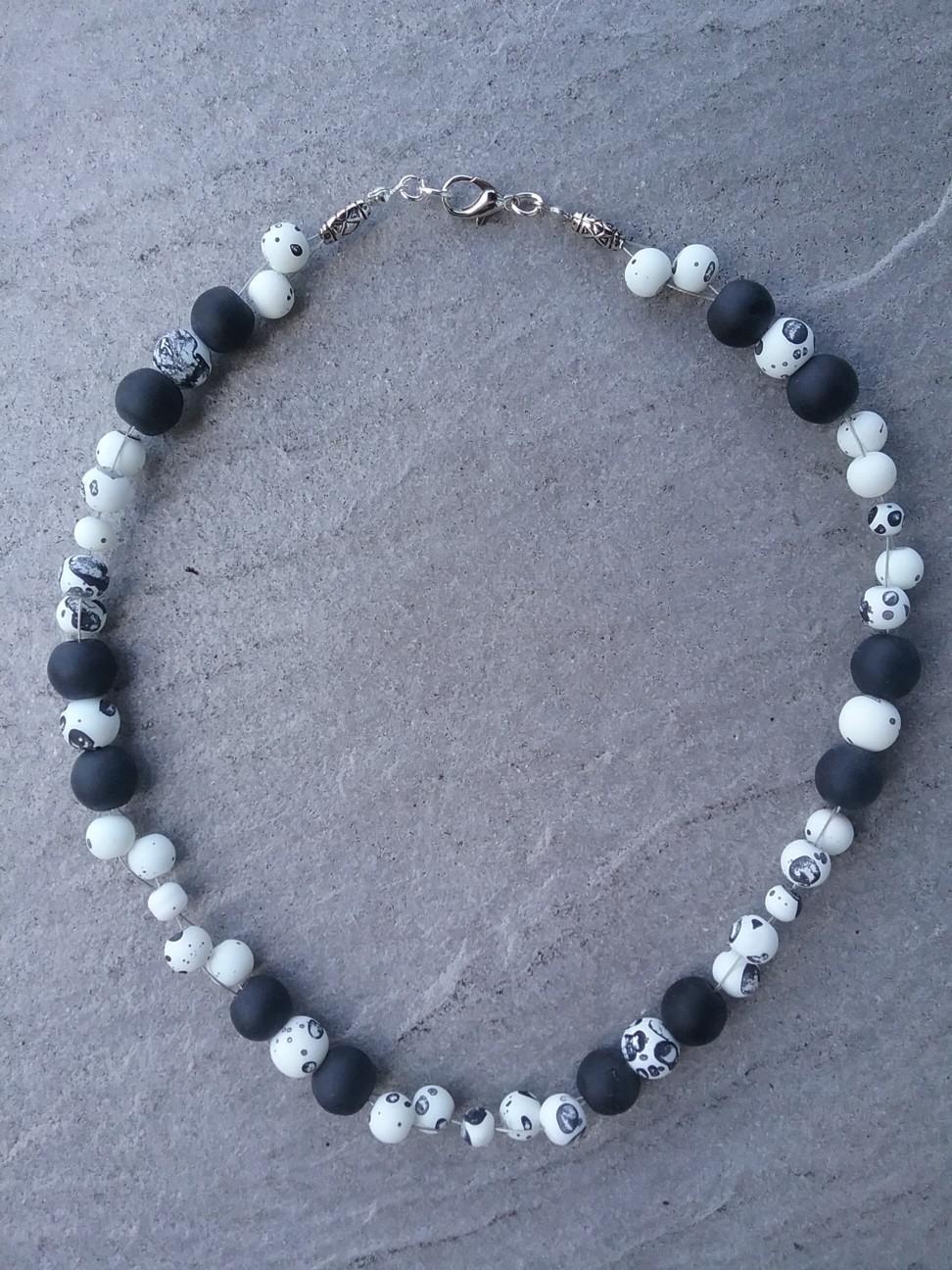 schwarzen Perlen einen metallfarbenen Doppeldraht.