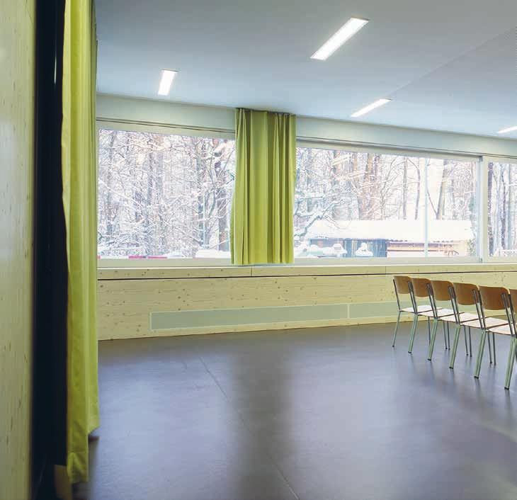 Ein mineralischer Putz in der Farbe der Schulanlage und die weissen, dreifach verglasten Holzmetallschiebefenster mit integrierten