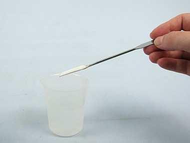 Gib in das Eiswasser fünf Spatel Kochsalz (Abb. 0), rühre etwas mit dem Glasstab um (Abb.