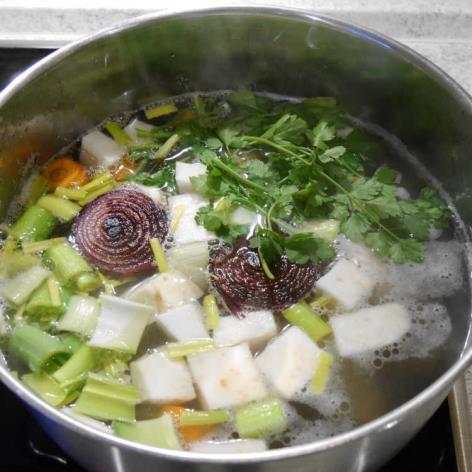 Das Suppengrün/Gemüse, Blattpetersilie, die zwei Zwiebelhälften, die Pfefferkörner,