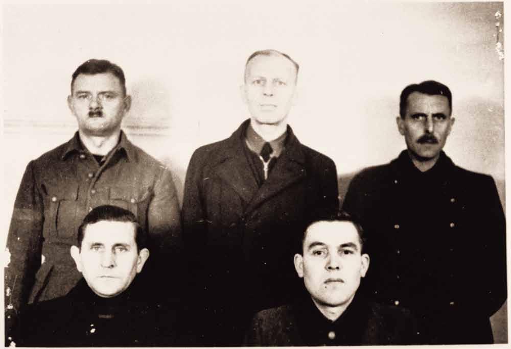 5 Während der britischen Militärgerichtsverfahren 1946 wurden die Angeklagten fotografiert. Das Gruppenbild zeigt Walter Kümmel hinten links.