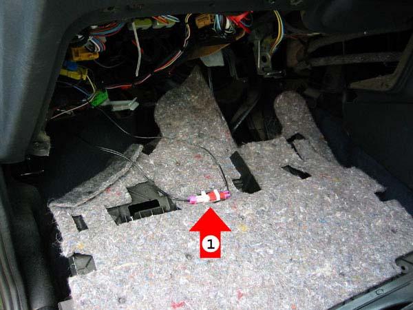2 Trennen der Airbag-Sicherung Die Sicherung (1) für den Airbag aus der Halterung auf der Oberseite des Ablagefachs herausnehmen.