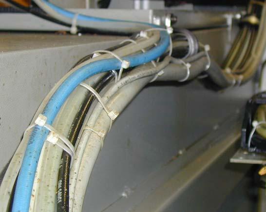 Beispiel: Installation einer Bearbeitungsmaschine Vorher Kabel und Schläuche werden mit Befestigungsschellen [1] und Kabelbindern [2] gesichert.