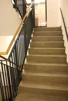 Es sind keine kontrastreichen Stufenflächen vorhanden. Es besteht kein visueller Kontrast zwischen dem Fußbodenbelag und Treppenauf- oder abgängen.