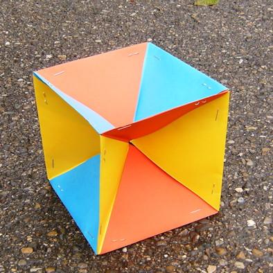 Dabei achten wir darauf, dass an jeder halben Raumdiagonale des Würfels drei Bauteile in den drei verschiedenen Farben zusammen kommen. Parallele Würfelkanten haben dieselbe Farbe. Abb.
