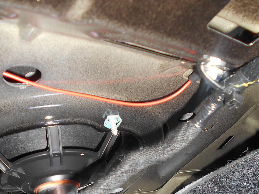 Das rote Kabel zum Anschluss der Kofferraumleuchte verlegen und mit Hilfe des Schwachstromverbinders