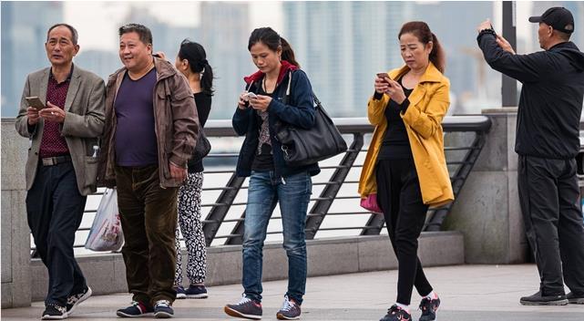 Menschen, die auf Smartphones starren: In China haben sie ihre eigene Straßenspur Digitalisierung von Staat und Gesellschaft Chancen für Gemeinden Während man auf Honolulu nun versucht, mit